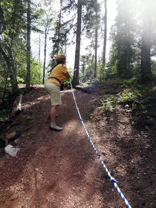 Karen Duquette using the rope to get up a steep hill